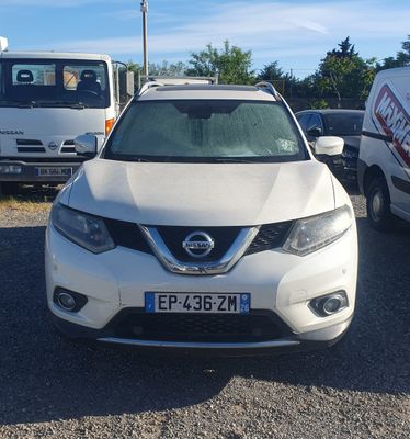 un SUV Nissan blanc garé sur un parking avec d'autres voitures