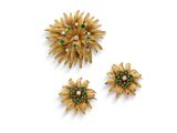 un ensemble de trois broches en forme de fleurs, en or et émeraudes