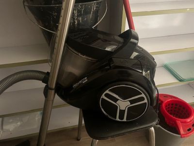 a vacuum and a bucket on the floor next to a window