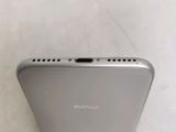 a close up of the back of a silver phone on a white surface