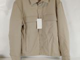 beige jacket hanging on a hanger in a white room