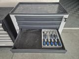 a tool drawer with tools inside of it on the floor