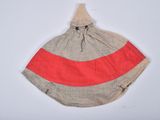 a red and grey striped bag hanging on a white wall