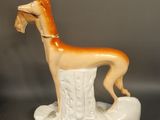 a figurine of a dog that is standing on a pedestal