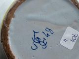 a close up of a vase with a tag on it