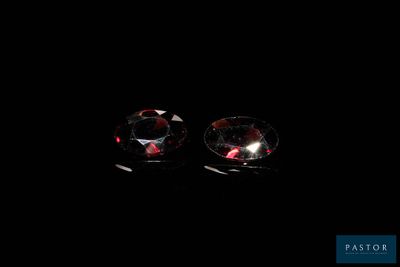 a pair of red diamond earrings on a black background