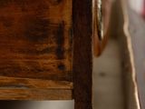a close up view of a wooden bed with a drawer