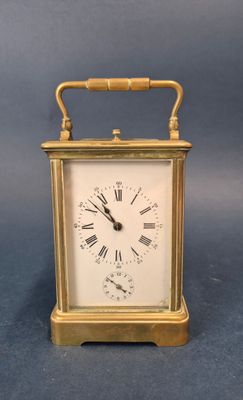 a small gold clock with roman numerals on it