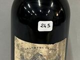 an old bottle of wine sitting on a table with a label on it