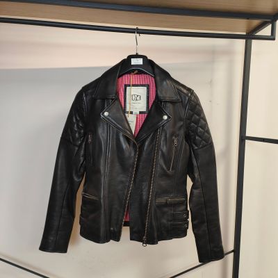 une veste en cuir noir suspendue à un portant dans une pièce