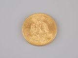 a close up of a gold coin on a white surface