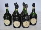four bottles of wine are lined up on a marble surface