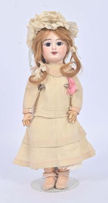 an old fashioned doll with a hat and dress on a white surface