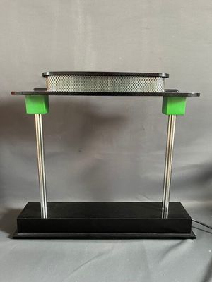 un gros plan d'une table en métal et en verre avec un piètement vert