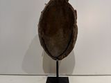a brown hat on a black stand on a white surface
