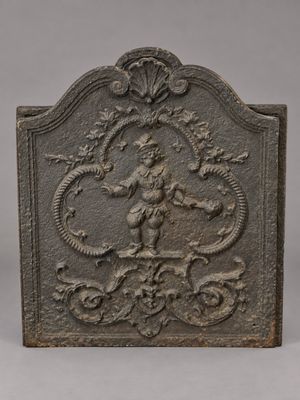 un pare-feu de cheminée ancien en fonte, orné d'une représentation d'une femme et d'un dragon