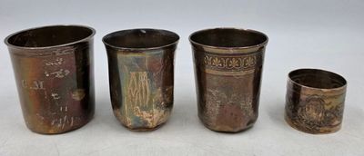 quatre tasses en métal de tailles différentes posées les unes à côté des autres sur une surface blanche