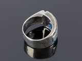 a close up of a silver ring with blue stones on a black surface