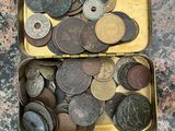 two tins filled with coins sitting on a table