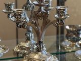 a silver candelab that is sitting on a glass table