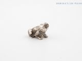 a close up of a silver object on a white surface