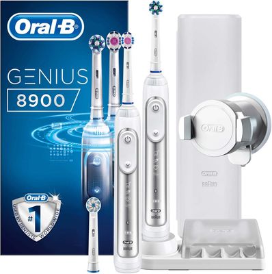 trois brosses à dents électriques posées à côté d'un tube de dentifrice