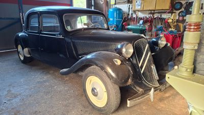 a black car parked in a garage next to a gas pump
