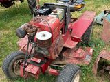 un tracteur rouge assis dans l'herbe