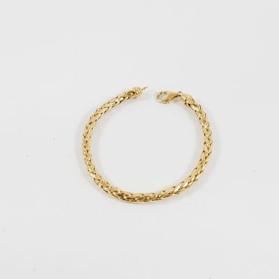 un bracelet en or avec un motif de tresse sur fond blanc