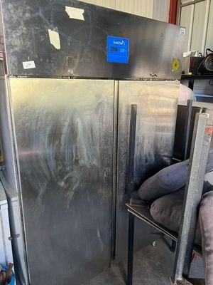 an image of a refrigerator in a garage with a lot of stuff