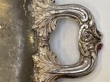 une assiette en argent avec un manche en argent et une cuillère en argent