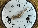 a gold clock with roman numerals on the face