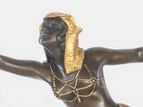 bronze statue of a woman with a gold headdress on her head