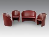 un ensemble composé de trois fauteuils en cuir rouge et d'une table
