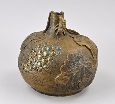 un petit vase orné d'une grappe de raisin