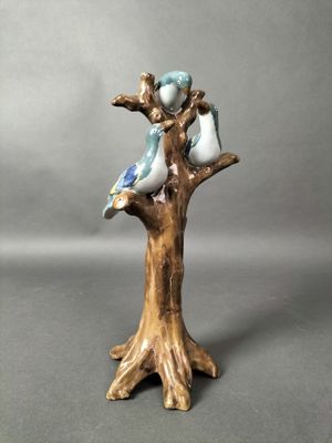 une figurine représentant deux oiseaux perchés sur une branche d'arbre