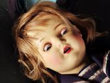 a doll that is laying down on a black surface