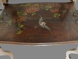 a wooden table with a bird and flowers on it