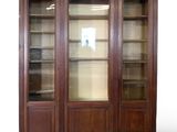 une photo d'une grande bibliothèque en bois avec des portes vitrées