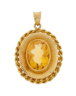 a close up of a pendant with a yellow stone in the center