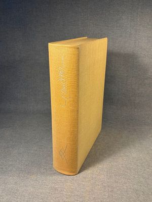 an old book sitting on top of a table next to a gray background