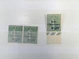 Plusieurs timbres différents sont exposés dans une vitrine.