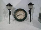 une horloge posée à côté d'un bougeoir