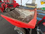 a red tractor and a red trailer in a garage