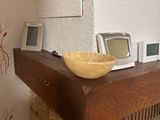 a wooden table with a bowl on top of it next to a fire place