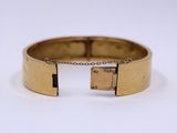 a close up of a gold bracelet with a lock on it