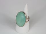 a close up of a ring with a green stone on it