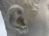 a white statue of a woman with a flower in her hair