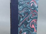 a close up of a book with a blue cover and a pink and blue cover