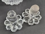 pair of clear glass candlesticks with a glass candle holder